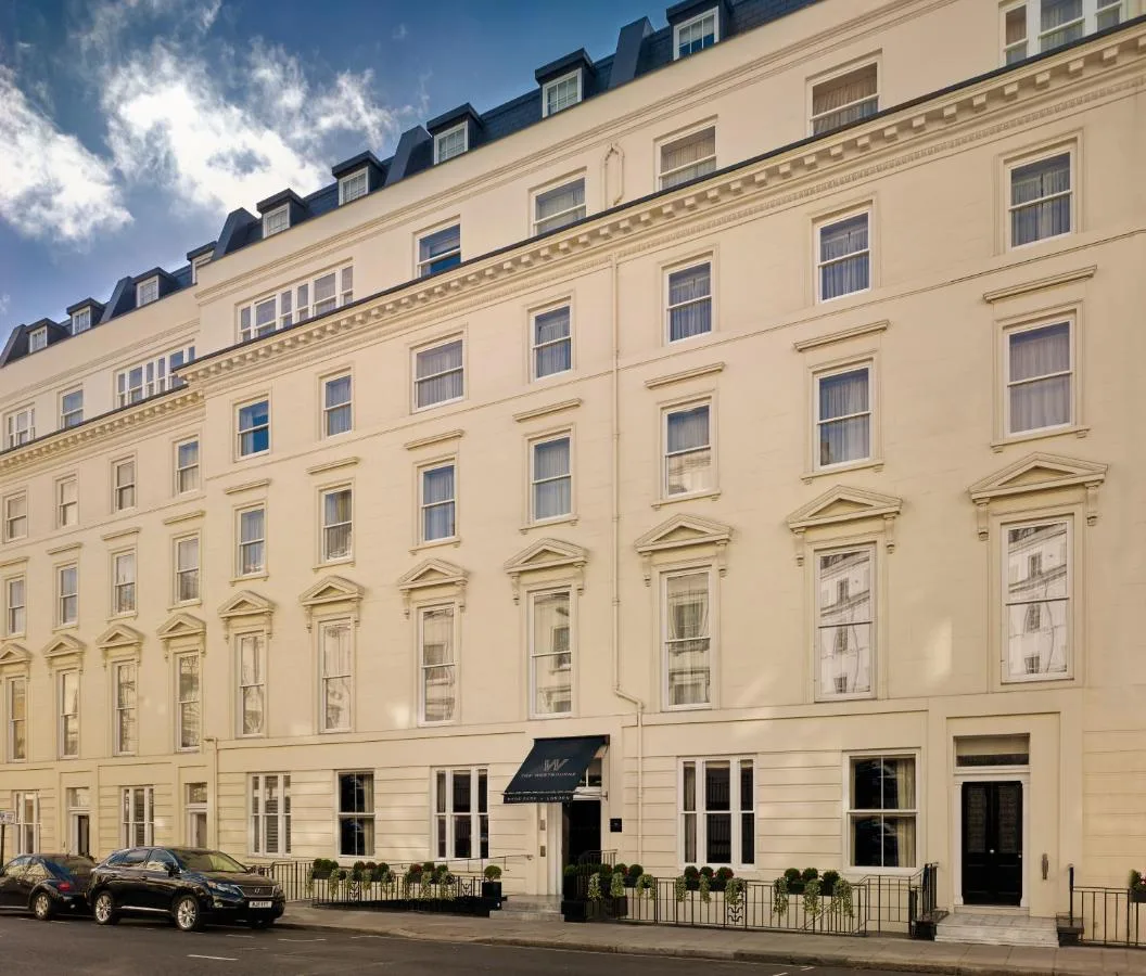 a large white building with cars parked in front of it at The Westbourne Hyde Park in London