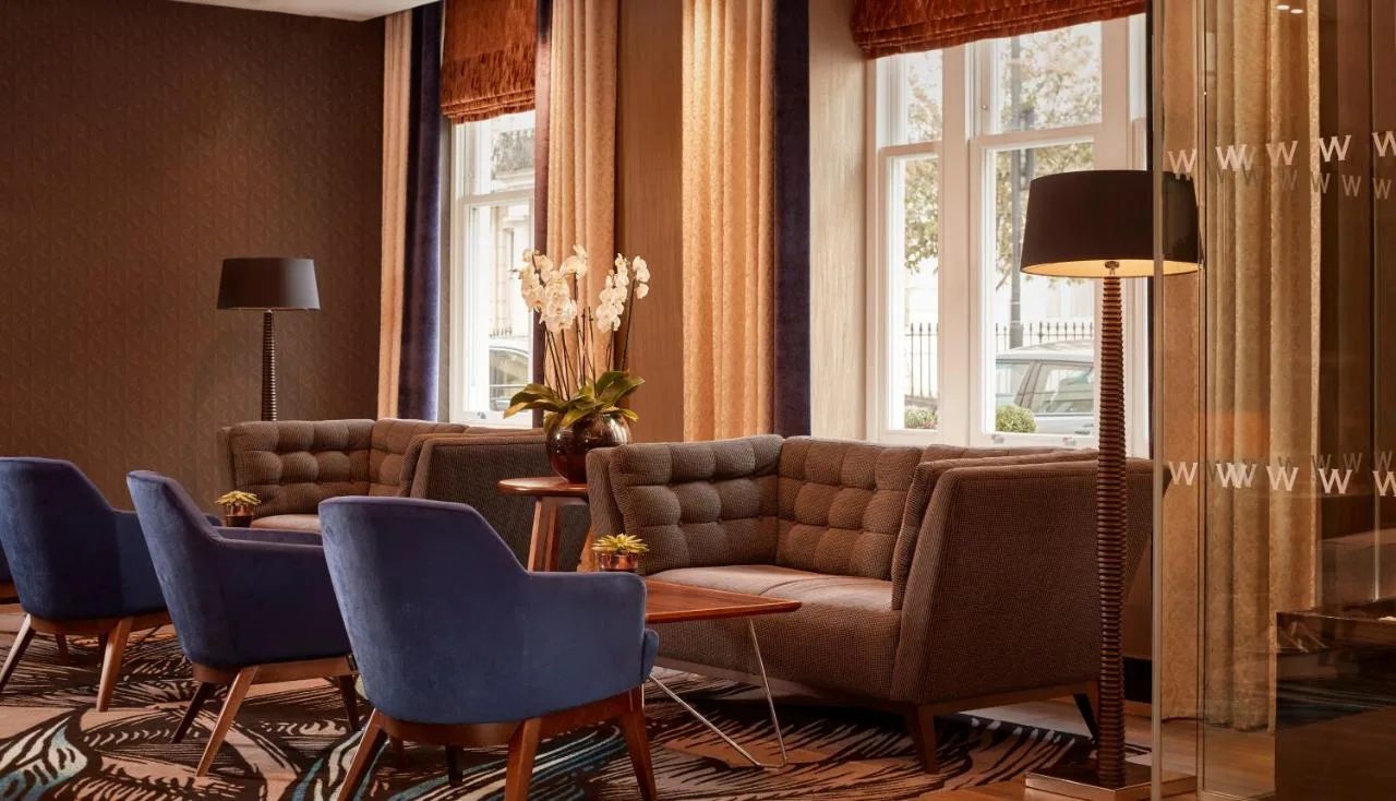a living room with a couch and blue chairs at The Westbourne Hyde Park in London
